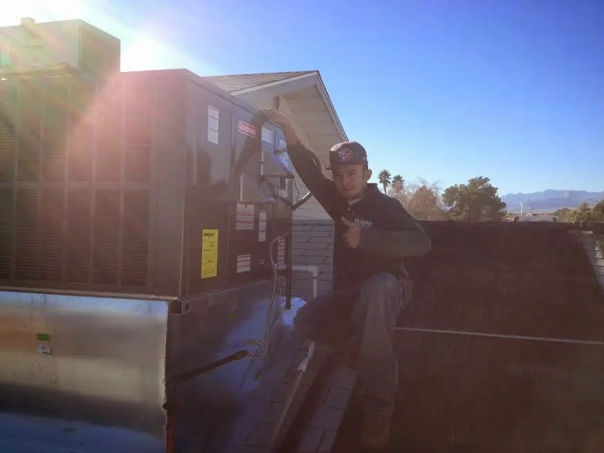 HVAC technician performing Air Duct Cleaning on a rooftop unit in Villa Park